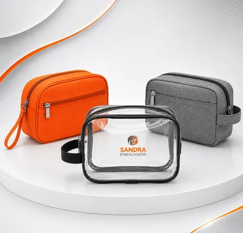 Três modelos de nécessaires promocionais personalizadas em PVC cristal e tecido, desenvolvidas para brindes corporativos, kits promocionais e ações de marketing da Sandra Embalagens.