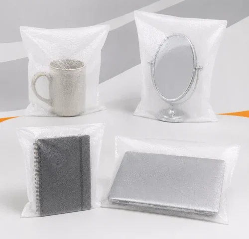Sacos de polietileno expandido (EPE) protegendo uma caneca de cerâmica, um espelho de mesa, um caderno espiral e um notebook, demonstrando a proteção contra riscos e impactos.