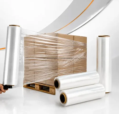 Filme stretch transparente sendo aplicado em pallet com caixas de papelão, acompanhado por bobinas de filme stretch em ambiente de estúdio.
