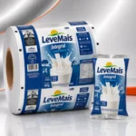 Bobina de filme metalizado para empacotamento automático de leite em pó ao lado da embalagem final produzida pelo mesmo filme.