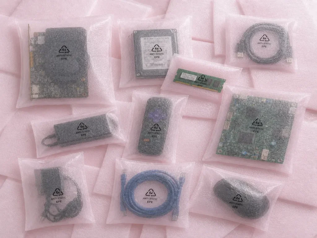 Sacos de polietileno expandido antiestático na cor rosa protegendo placas de circuito, mouses e hardwares industriais.