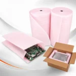 Bobinas de manta EPE antiestática rosa protegendo placa e equipamento eletrônico em caixa.